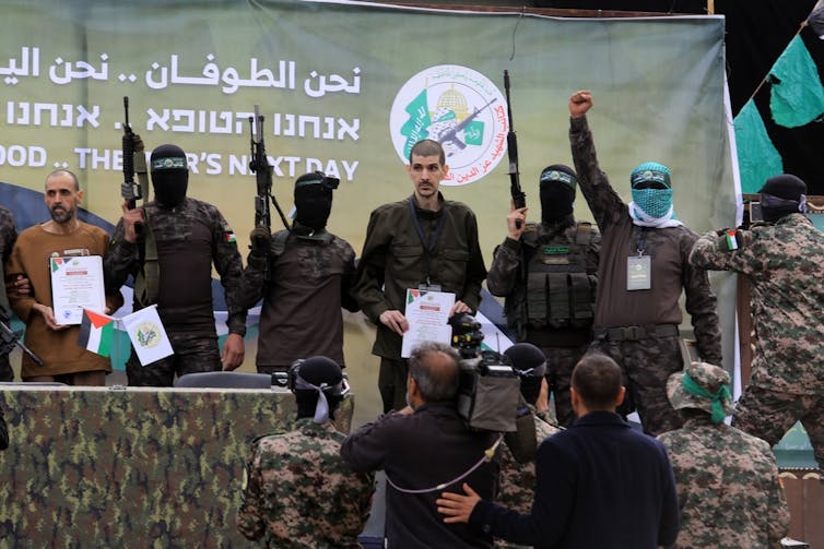 An Israeli hostage flanked by militants in Gaza