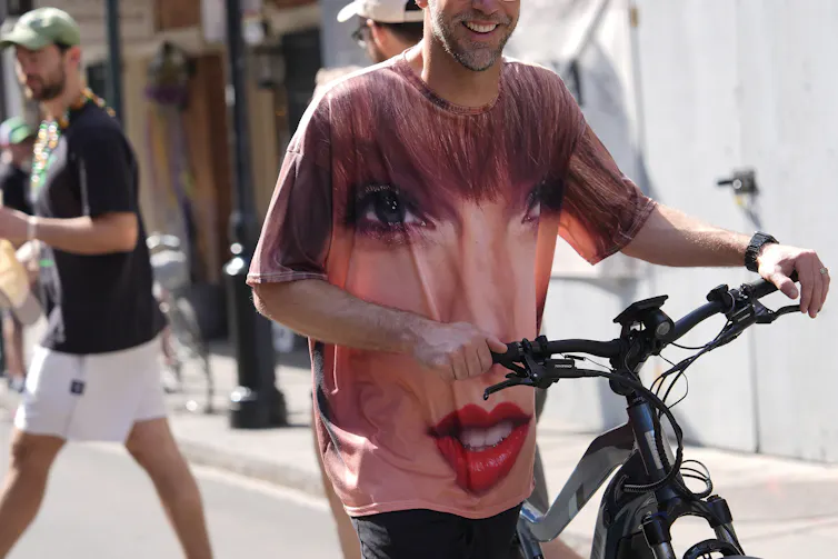 a person wearing a tshirt with a woman's face pushes a bike