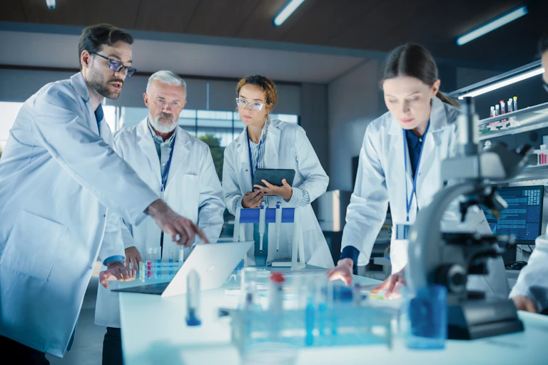 Científicos en un laboratorio observando algo en un ordenador portátil