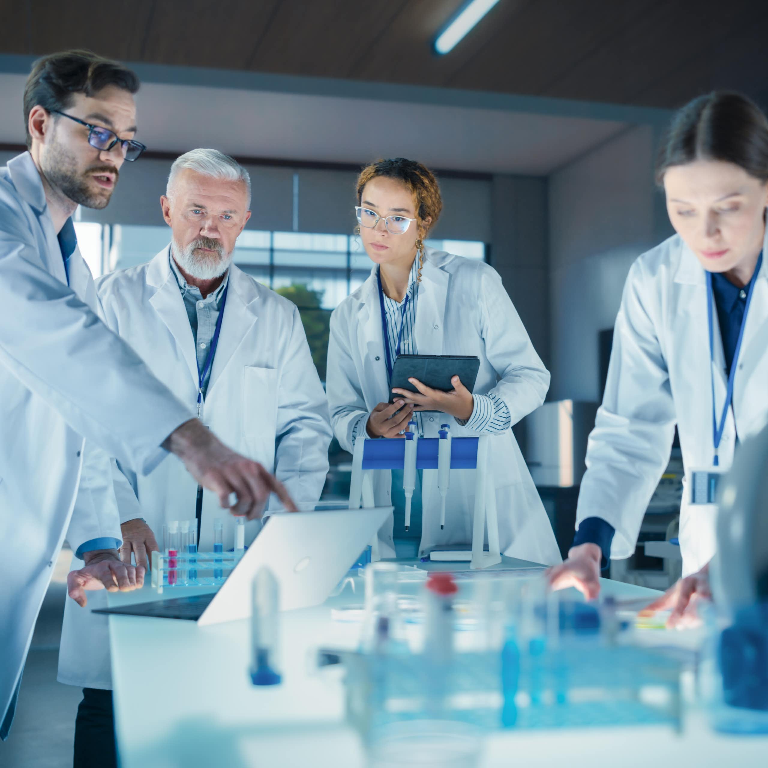 Científicos en un laboratorio observando algo en un ordenador portátil