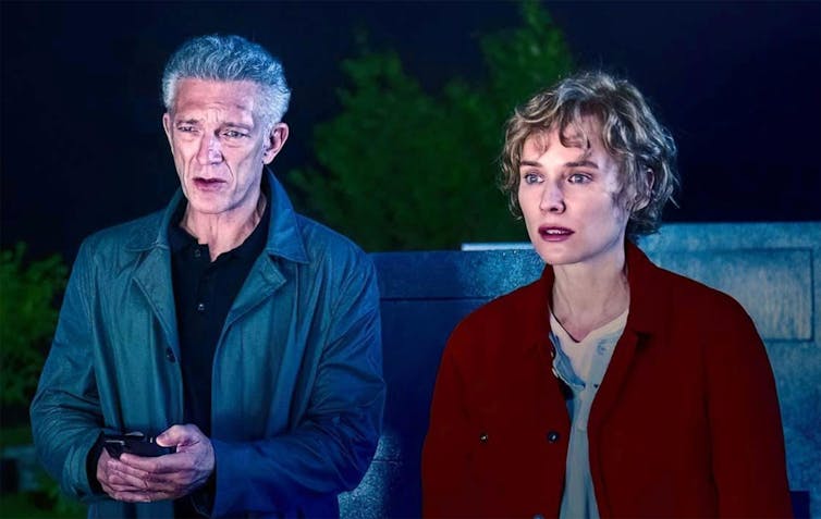 A middle-aged man with grey hair and a younger woman with blonde hair standing side by side.
