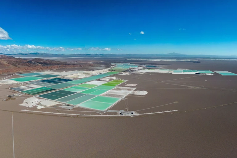 aerial shot of desert eith bright blue grid of lithium mining, blue sky