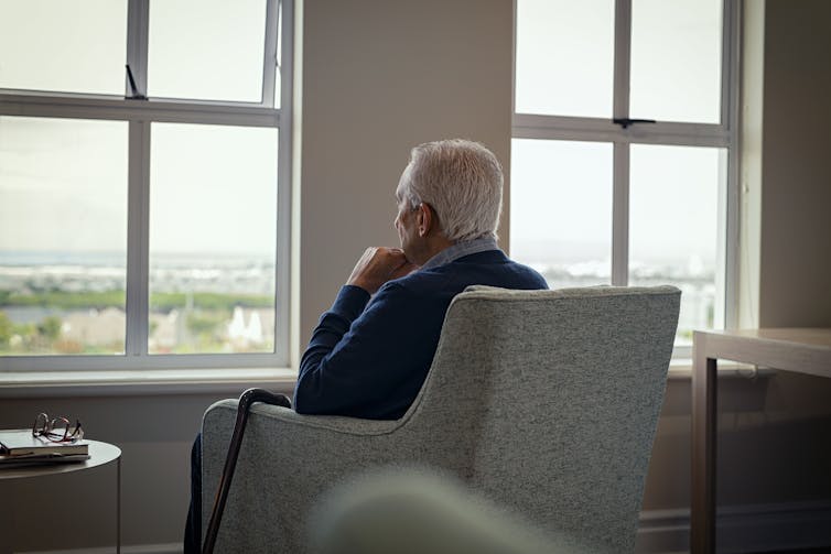 Rear view of a senior man in an armchair.