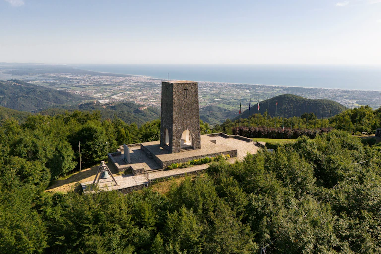 A memorial in Stazzema in Italy to a Nazi massacre with the Tuscan hills behind.
