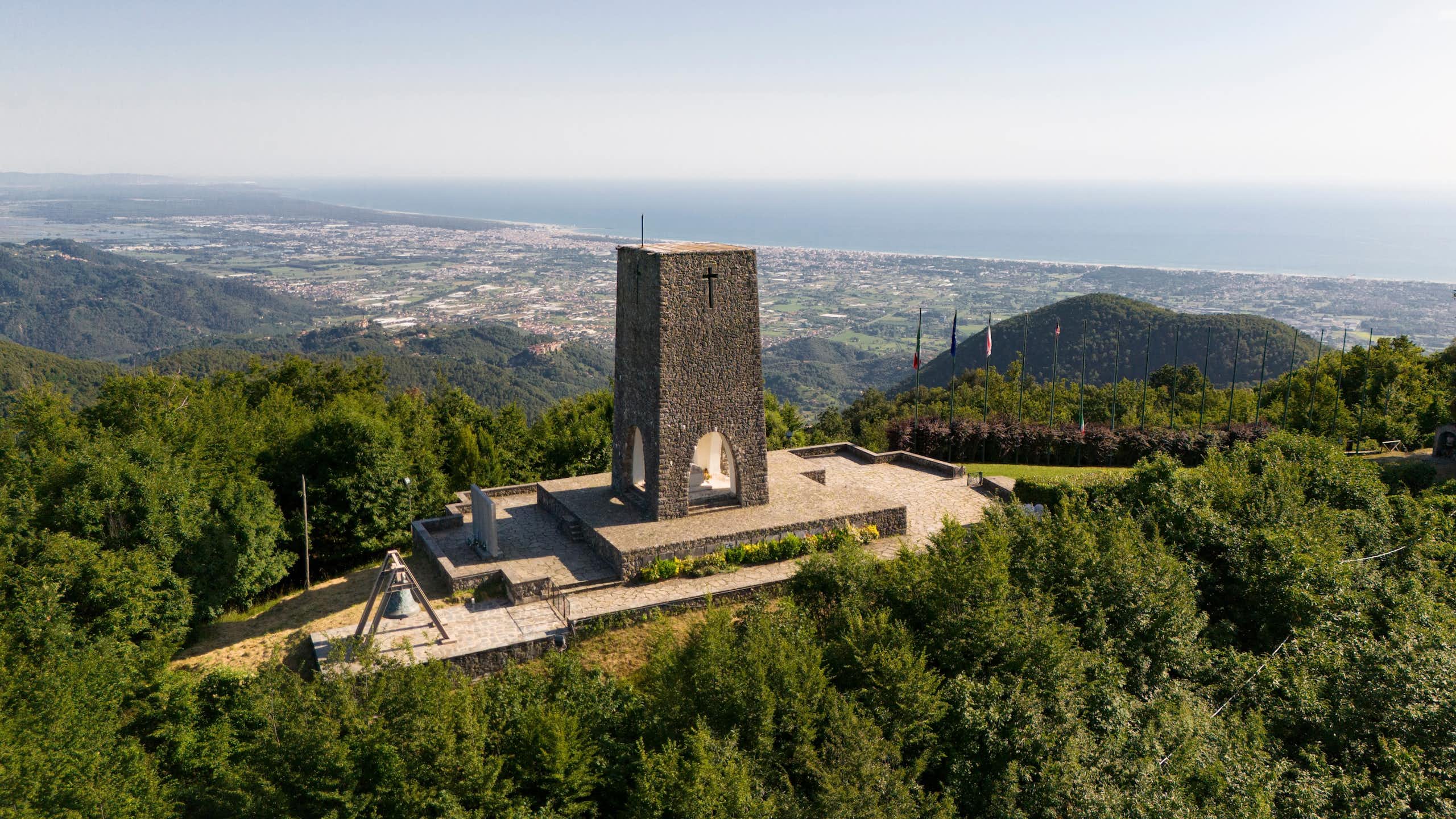 A memorial in Stazzema in Italy to a Nazi massacre with the Tuscan hills behind.