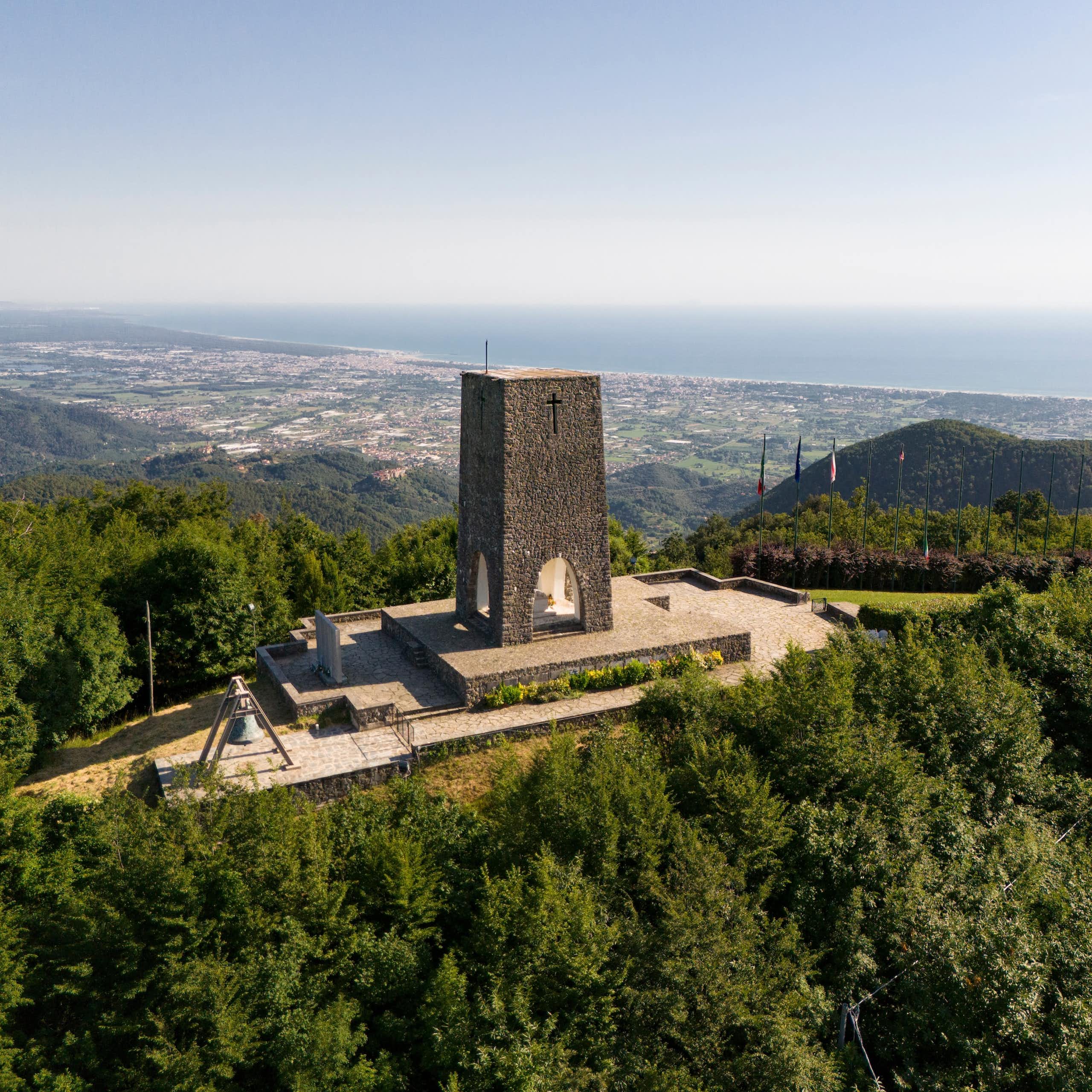 A memorial in Stazzema in Italy to a Nazi massacre with the Tuscan hills behind.