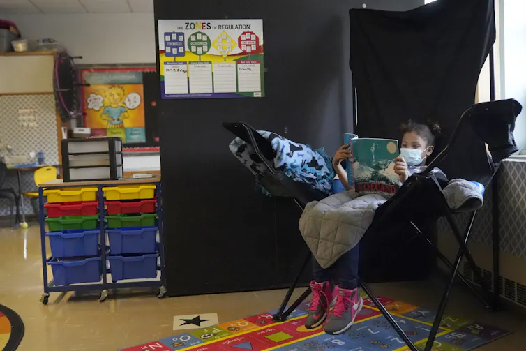A child in a chair reading.