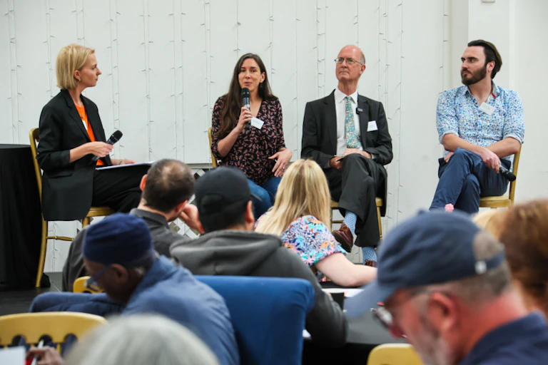 experts speak with microphones in front of audience at citizens assembly