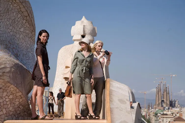 Tres mujeres hacen fotos en Barcelona con la Sagrada Familia al fondo.
