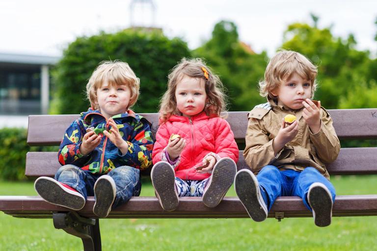 Three children sat on bench