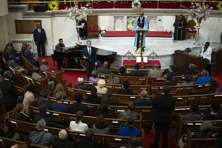 Man in a suit speaks at a church service.