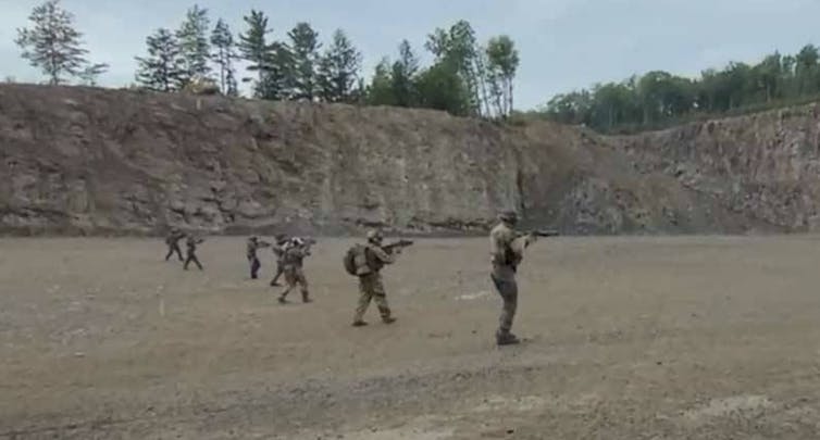 Hombres en neumáticos de combate haciendo entrenamiento militar
