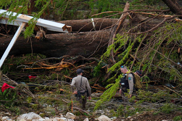 A first responder searches an area along the Guadalupe River that hit by flash flooding, Friday, July 4, 2025, in Kerrville, Texas
