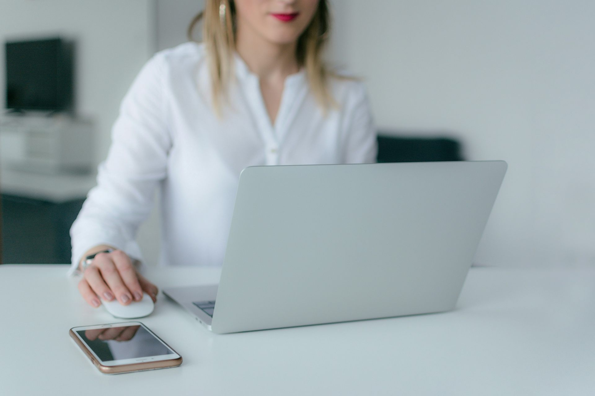 Une femme assise à son bureau regarde son ordinateur