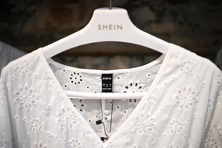 Clothes are displayed on hangers at a Chinese-founded fashion brand Shein pop-up store in Paris on May 4, 2023.