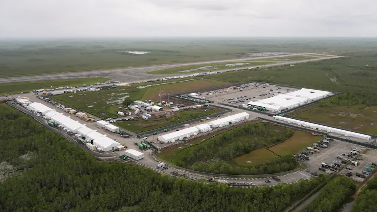 An aerial photo of a large facility amid a swampy expanse.