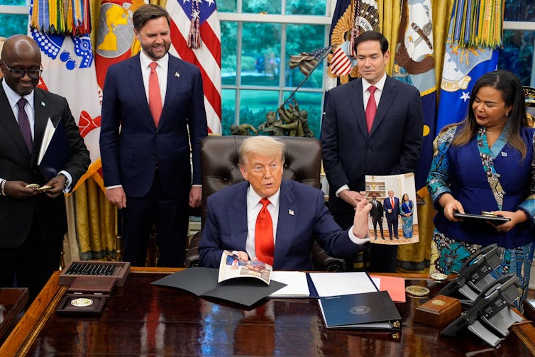 Donald Trump surrounded by Ministers and officials in the Oval Office