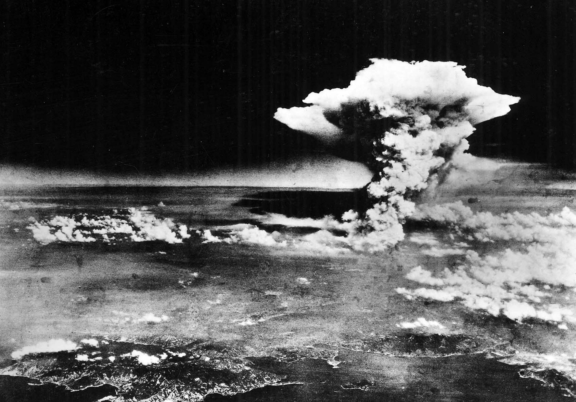 Black and white image of the atomic mushroom cloud over Hiroshima, Japan.