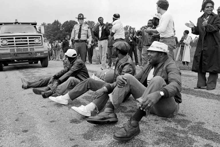 Des manifestants afro-américains lors d'un sit-in sur une route pour empêcher des camions chargés de terre contaminée d'atteindre un projet de décharge.