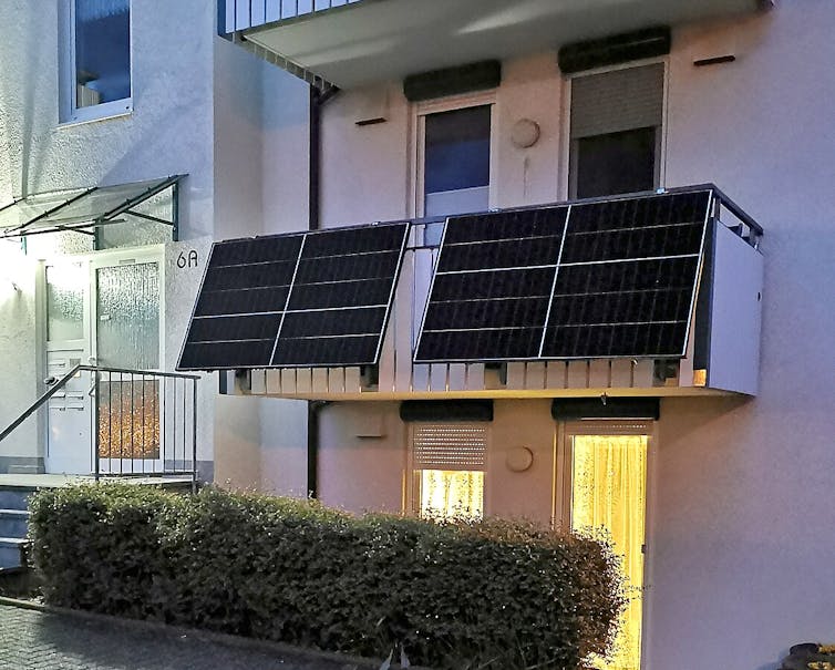 A first-floor flat with two solar arrays tilted slightly over the balcony.