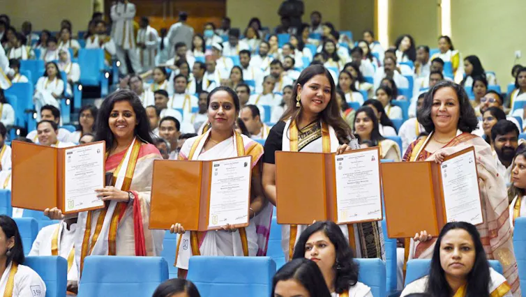 Jawaharlal Nehru University students show their degrees during a convocation ceremony