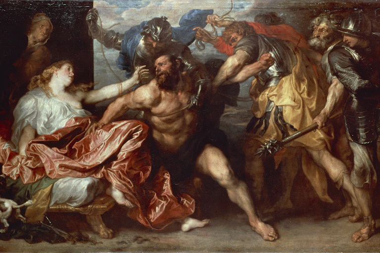 A man with a bare upper body is being taken away while a woman by his side extends her arm toward him.