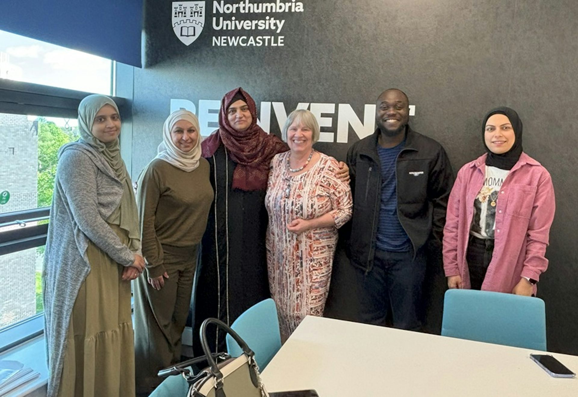 La gente de pie en una fila sonríe.