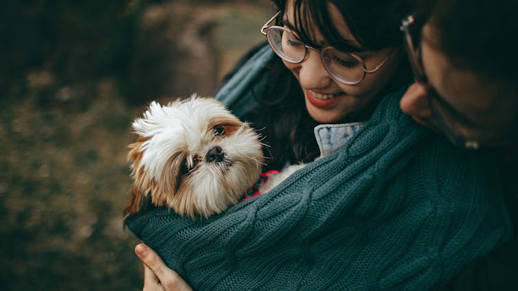 A woman cuddles her dog