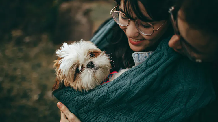A woman cuddles her dog
