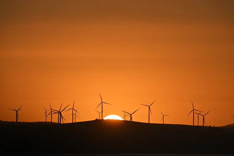 a wind farm against a setting sun