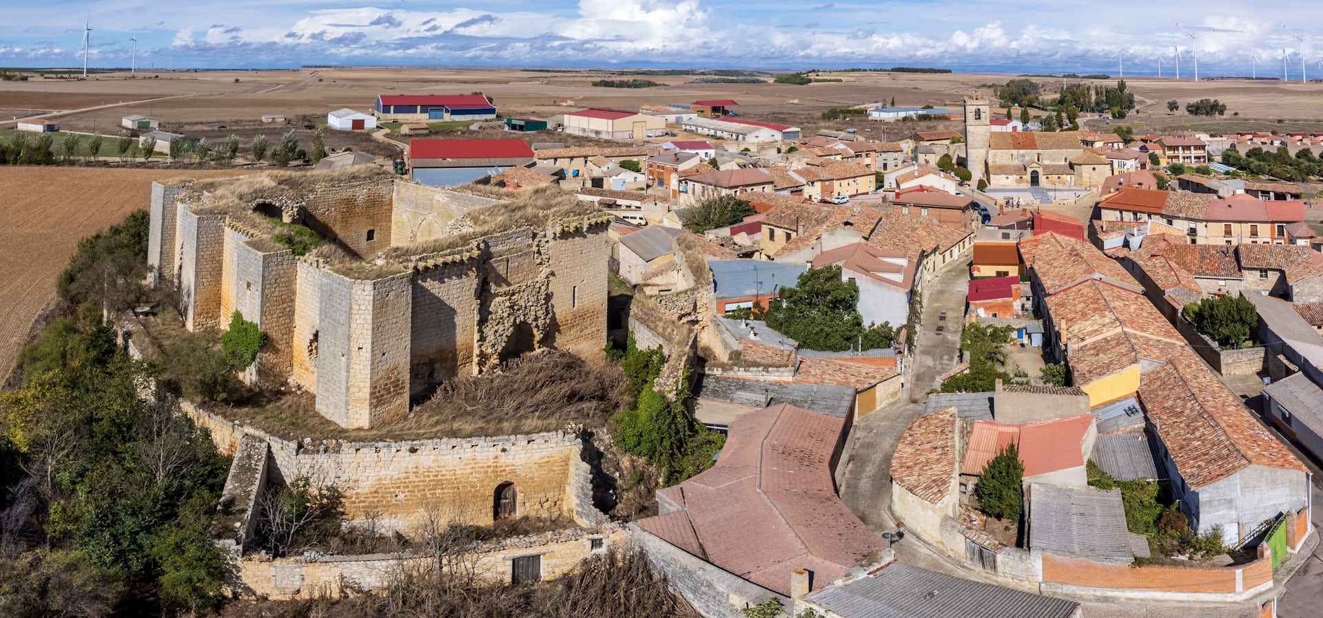Vista a vista de pájaro de un pueblo castellano con un castillo a la izquierda.
