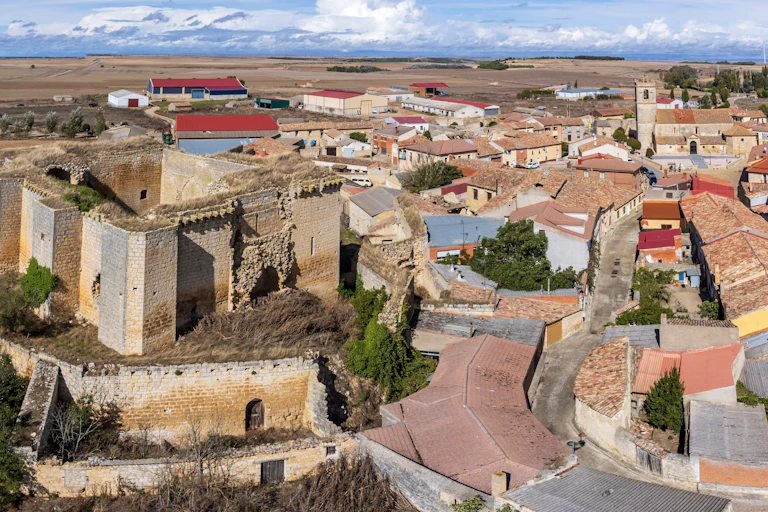 Vista a vista de pájaro de un pueblo castellano con un castillo a la izquierda.