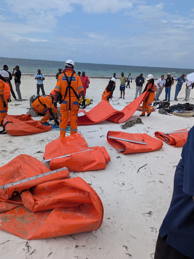 People dressed in orange suits prepare for the emergency exercise.