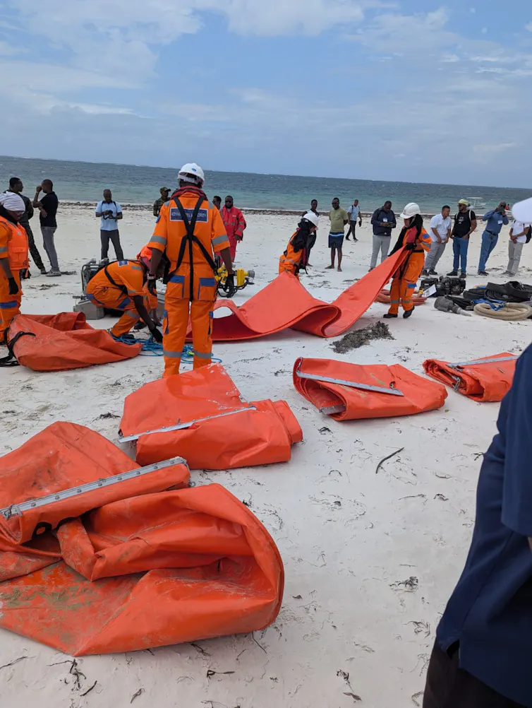 People dressed in orange suits prepare for the emergency exercise.
