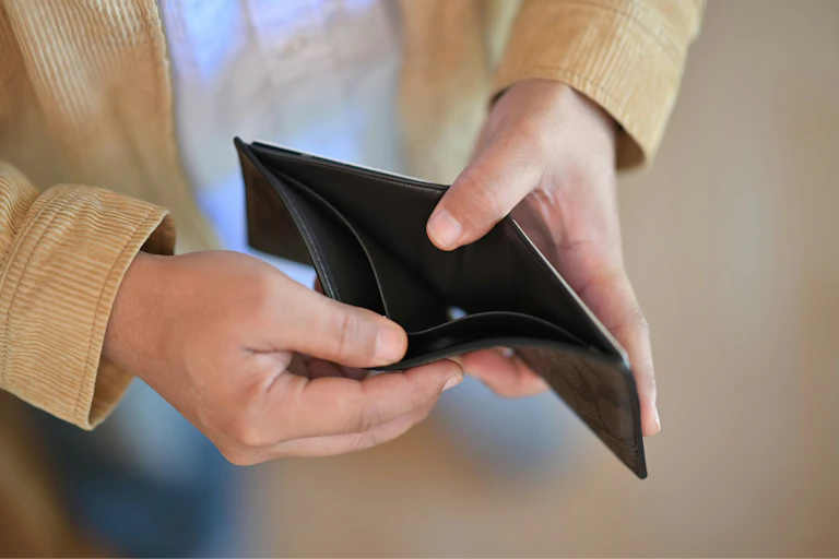 A pair of hands holding open an empty wallet