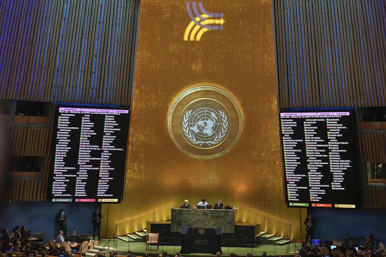 two large screens flanking a podium with the United Nations logo