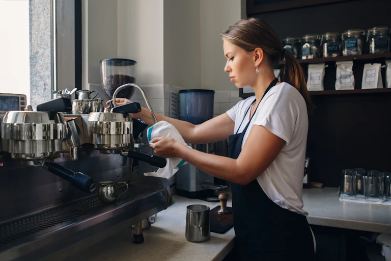 Woman cleaning a coffee machine