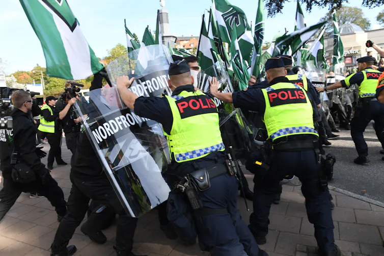 Nordic Resistance Movement demonstrators clash with police officers during a march.