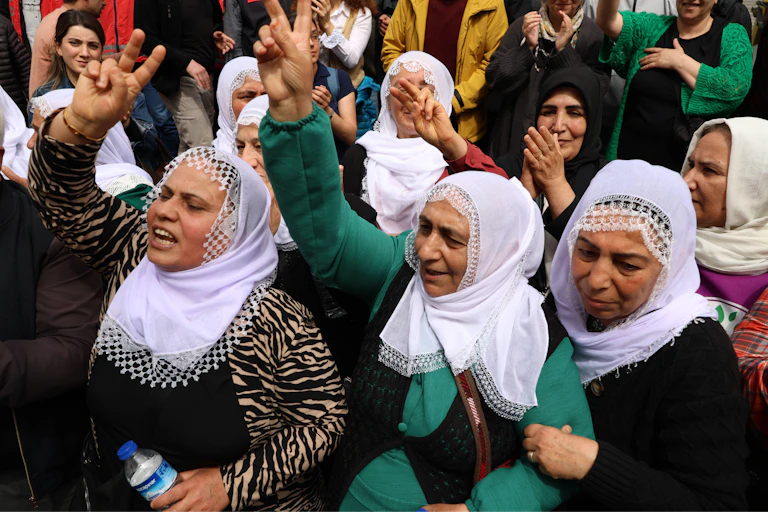 A group of Kurdish woman raise their hands to celebrate the birthday of PKK leader Abdullah Öcalan in April 2025.