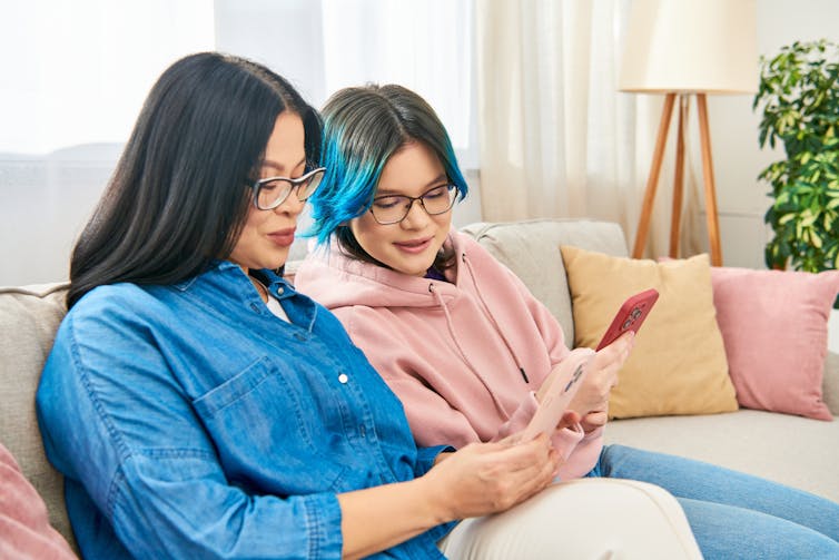 Parent and teen girl looking at phones