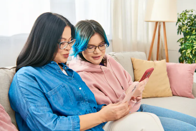 Parent and teen girl looking at phones