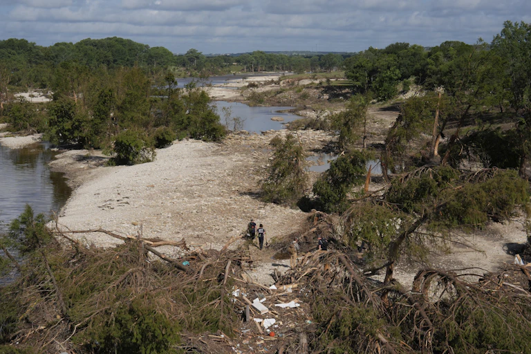 people walk across a flooded landscape