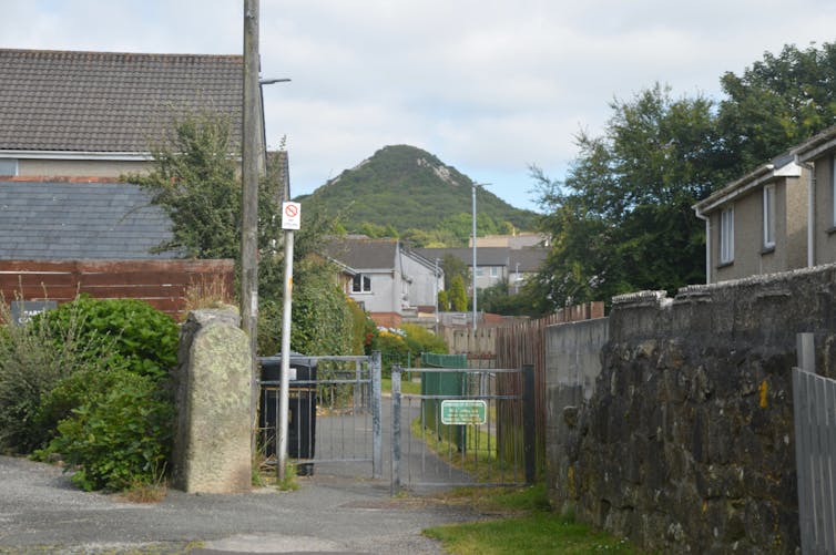 mound of land in background, houses and street in cornish village