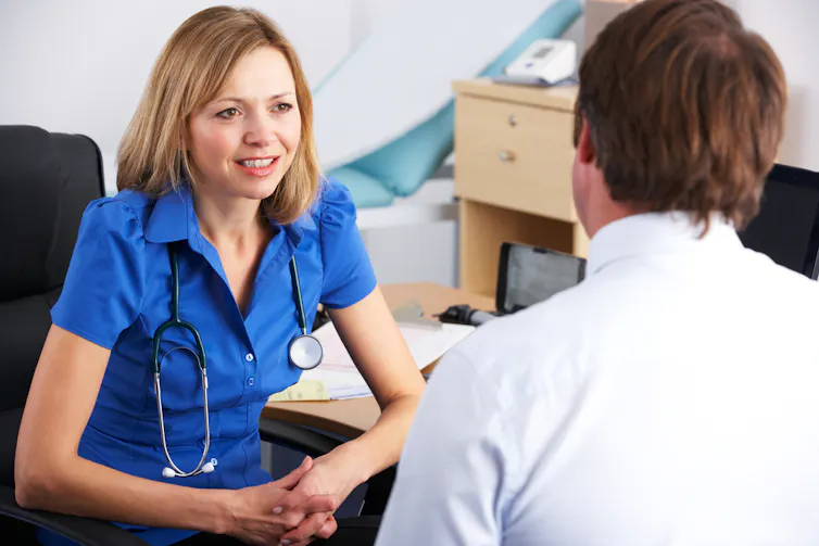 A female GP talking to a male patient.
