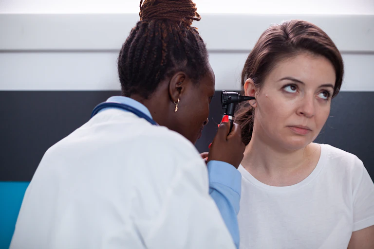 Otology specialist checking a patient's ears