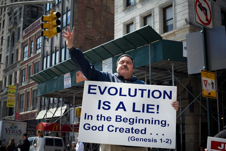 Street preacher holding a sign that says evolution is a lie.