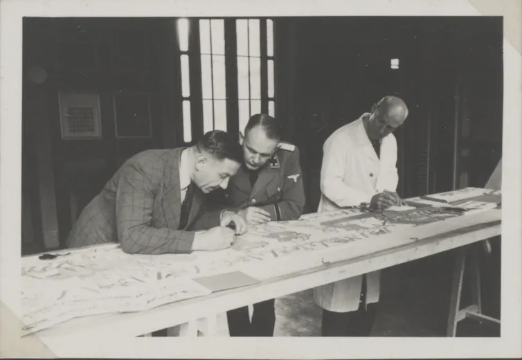 Trois hommes observant une tapisserie