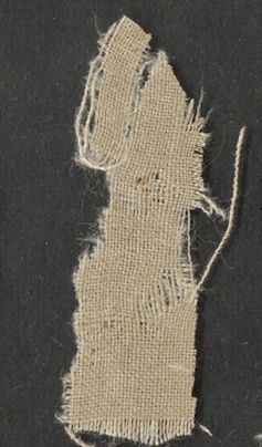 A ragged piece of woven cloth fragment.