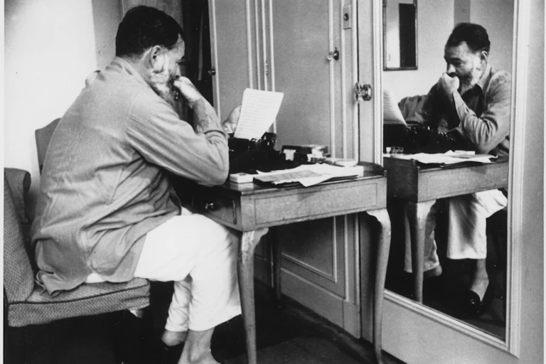 Ernest Hemingway escribiendo en un hotel en Londres.