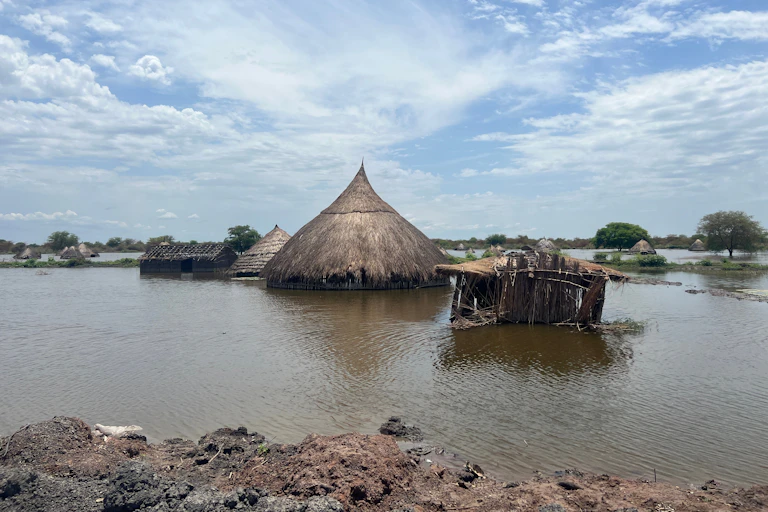 Huts and one roomed homes submerged in water after a flood